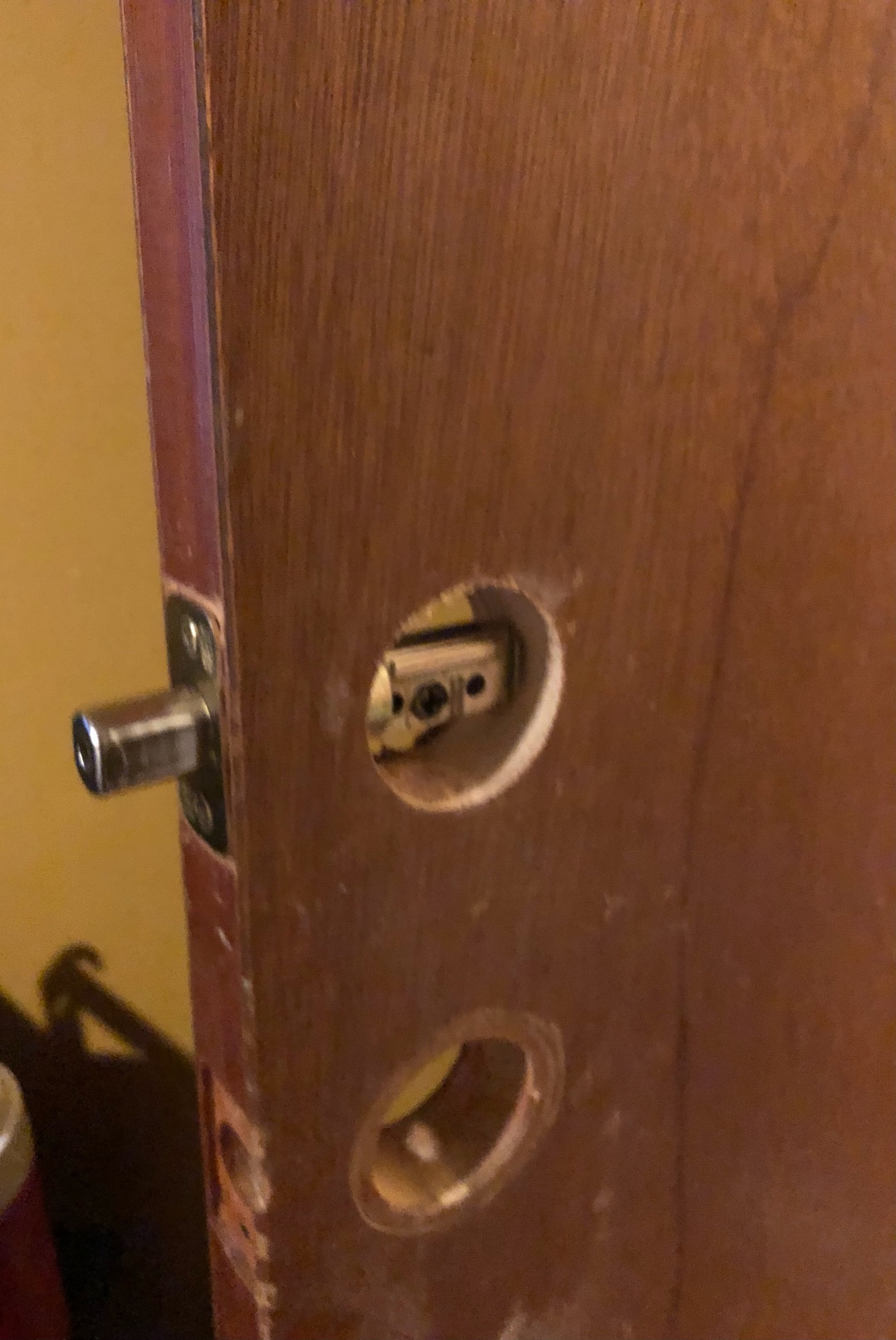 Close-up of a wooden door bored for a new deadbolt and latch